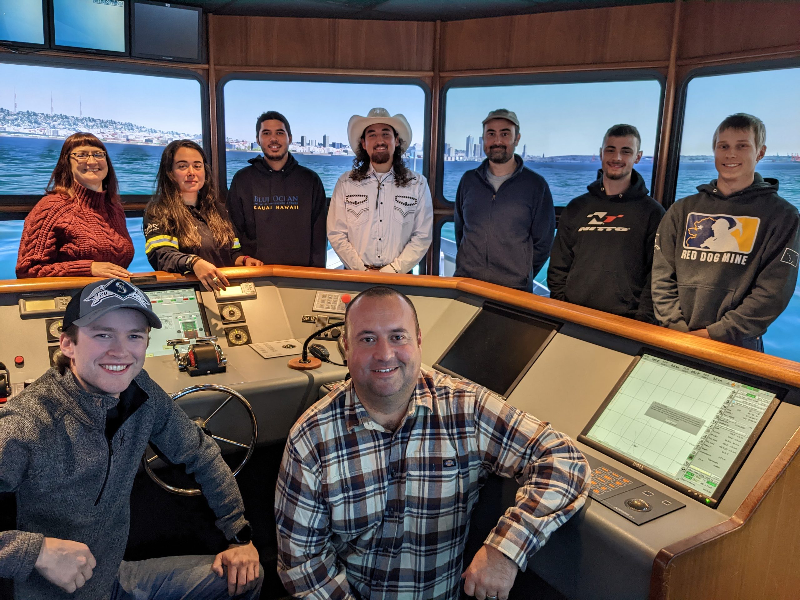 Group of students and faculty in a ship simulator.